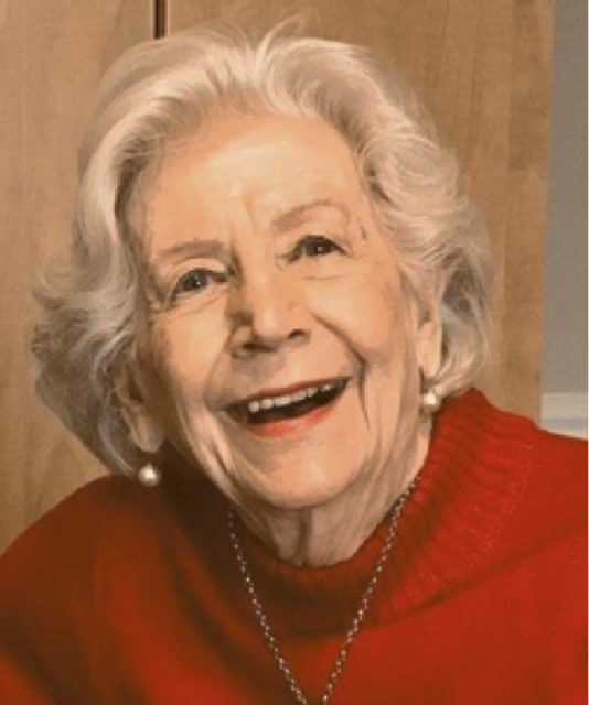 A woman smiling wearing a red sweater