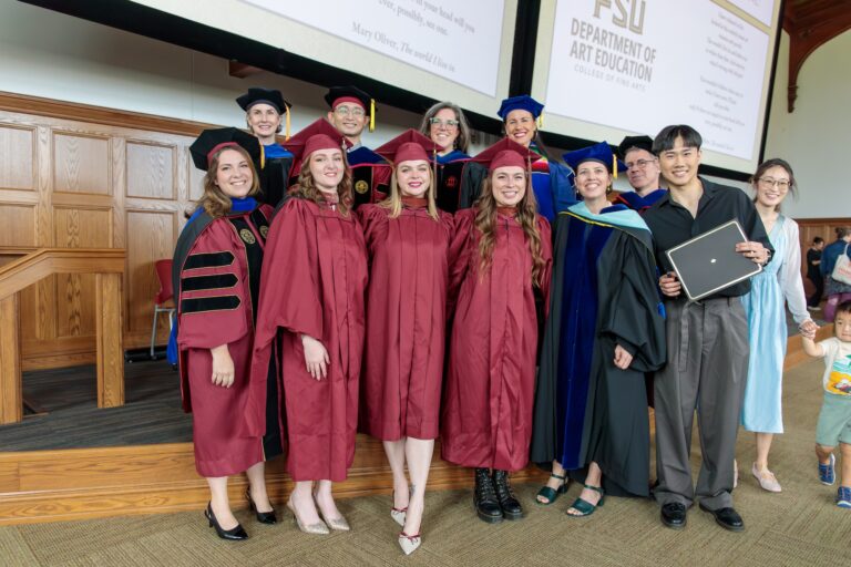 there is a group of graduates posing for a picture in front of a projector screen