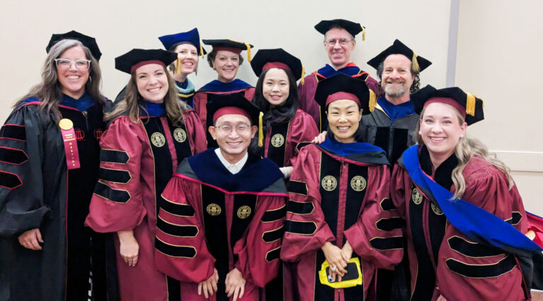 a group of graduates pose for a photo in their caps and gowns